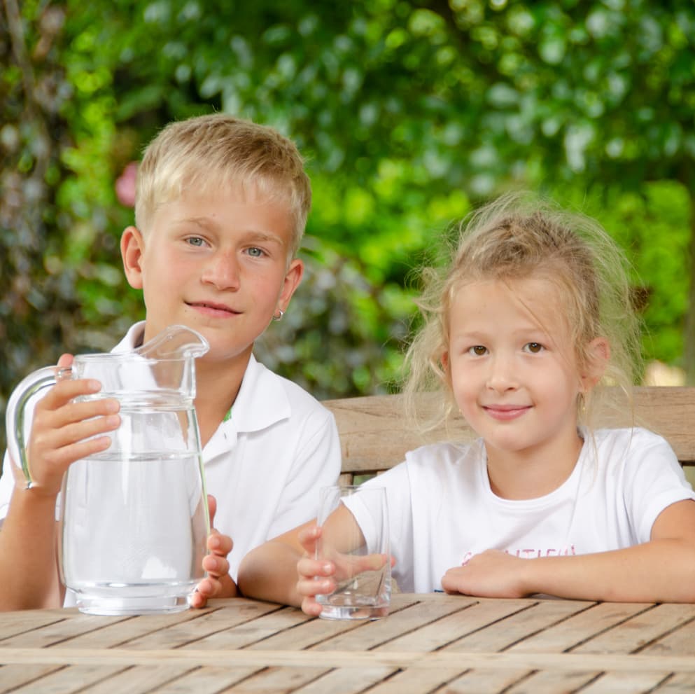 Kinder im Garten trinken sauberes Wasser von VISION AQUA