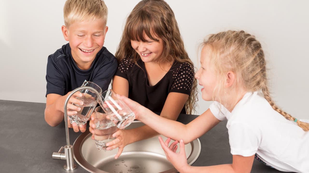 Kinder möchten gleichzeitig sauberesWasser in ihre Gläser füllen